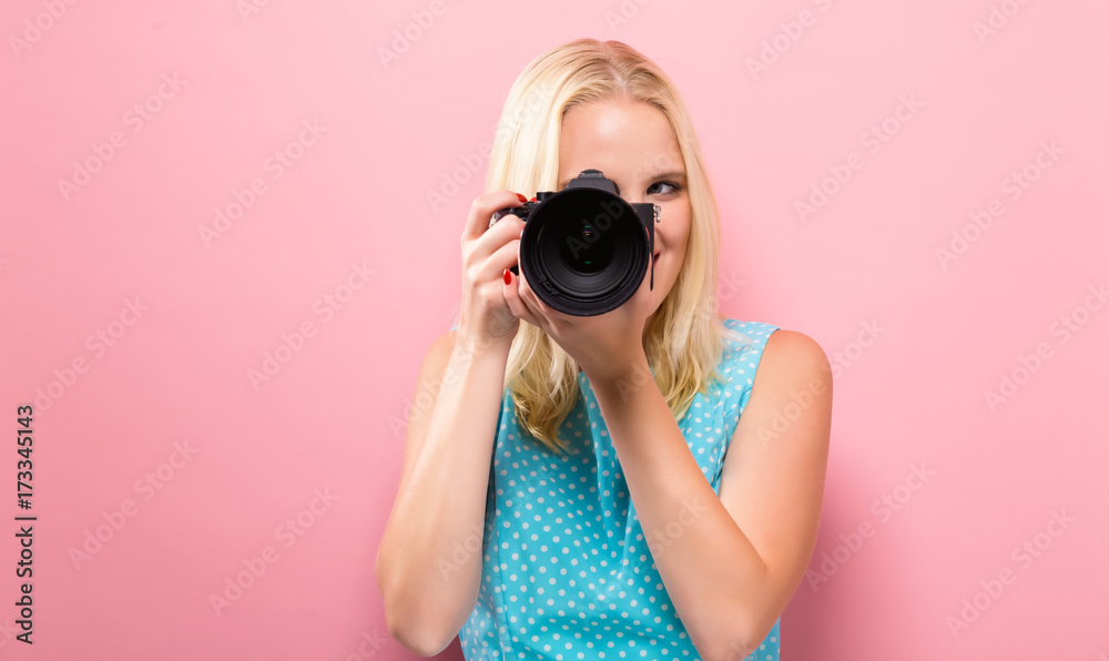 Young woman comparing professional camera on a solid background Young woman comparing professional camera on a solid background