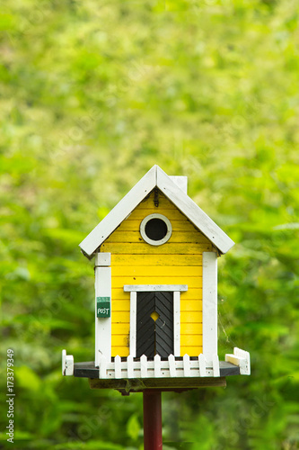 Yellow birdhouse in a garden
