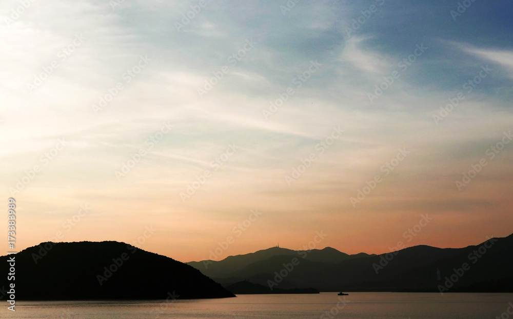 The silhouette of boat and mountain with gradient sunset