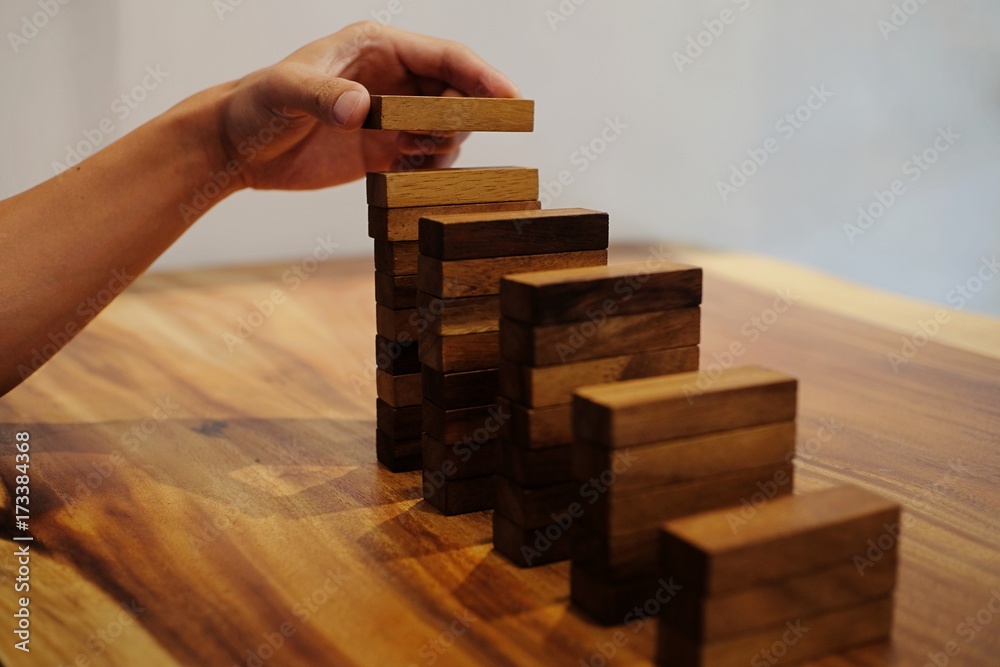 Planning risk and strategy in businessman gambling placing wooden block.Business concept for growth success process Planning risk and strategy in businessman gambling placing wooden block.Business concept for growth success process