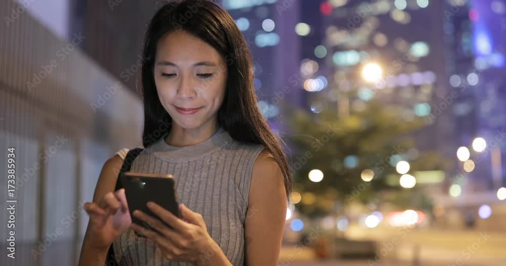 Asian Woman using mobile phone in city at night Asian Woman using mobile phone in city at night