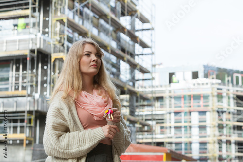 Woman with keys on front of new house building