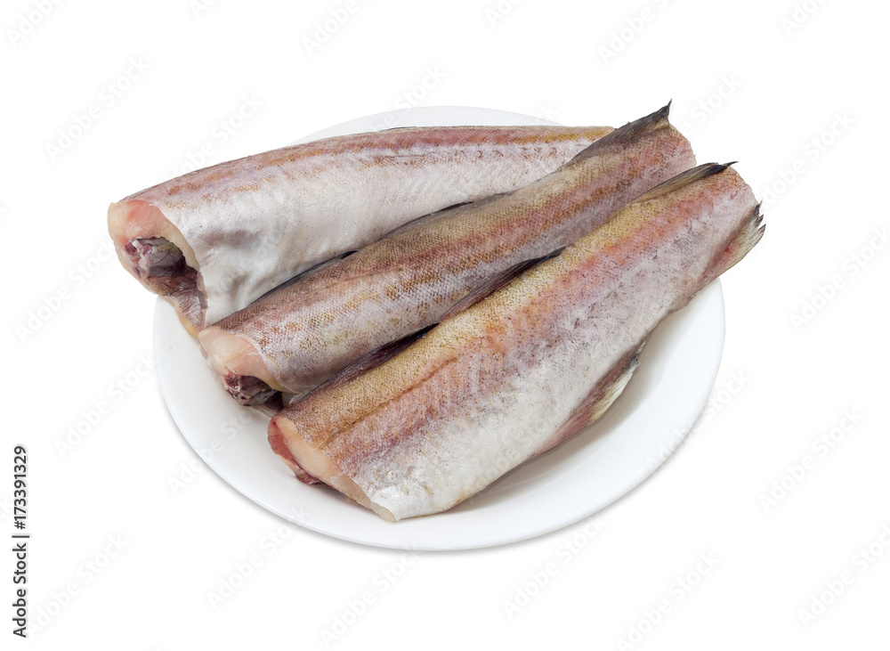 Uncooked carcasses of the Alaska pollock on a white dish Uncooked carcasses of the Alaska pollock on a white dish