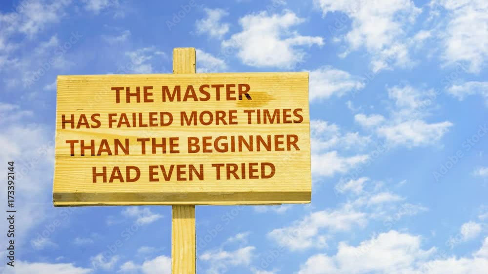 The master has failed more times than the beginner had even tried. Words on a wooden sign against time lapse clouds in the blue sky. 