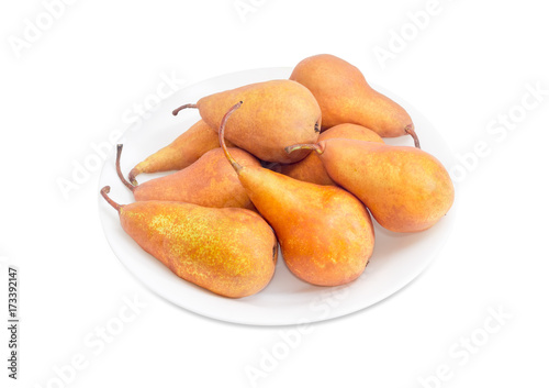 Several Bosc pears on a white dish