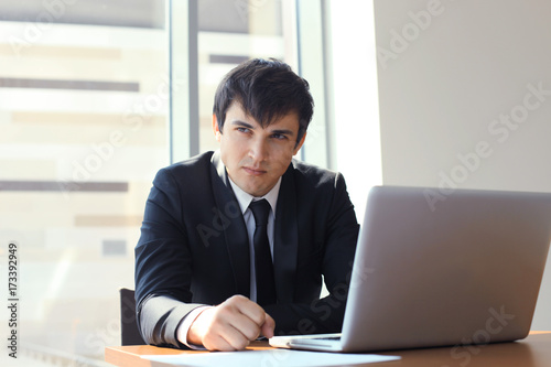 Young businessman working in the office with laptop.