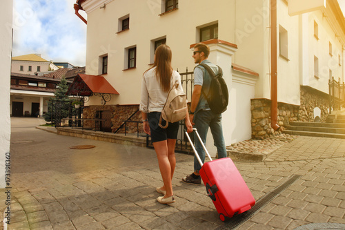 Two travelers on vacation walking around the city with luggage. photo