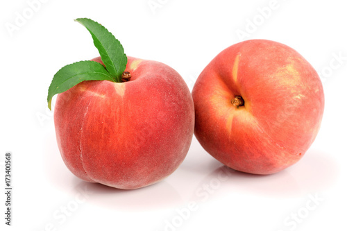 Two peaches with green leaf isolated on white background