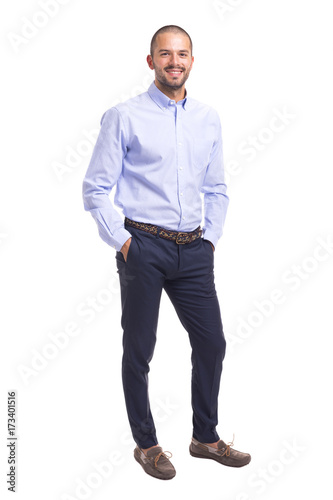 Young business man standing with hands in pockets on a white background
