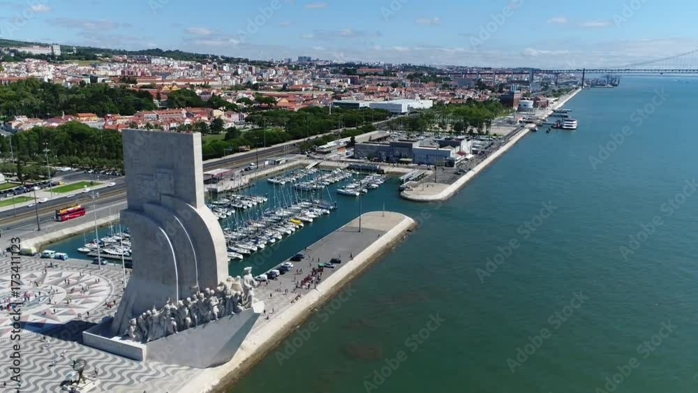 Aerial Lisbon flying towards Monument of Discoveries in Portuguese Padrao dos Descrobrimentos also showing Marina de Belem in background the memorial is located on northern bank of Tagus River estuary