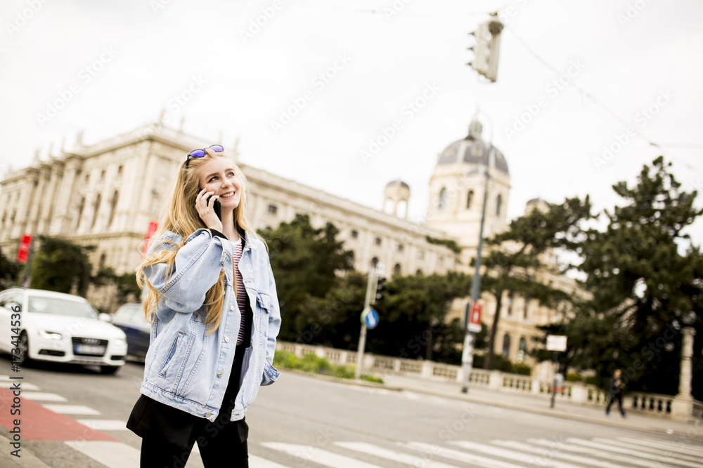 Fototapeta premium Young woman with mobile phone on the street of Vienna, Austria