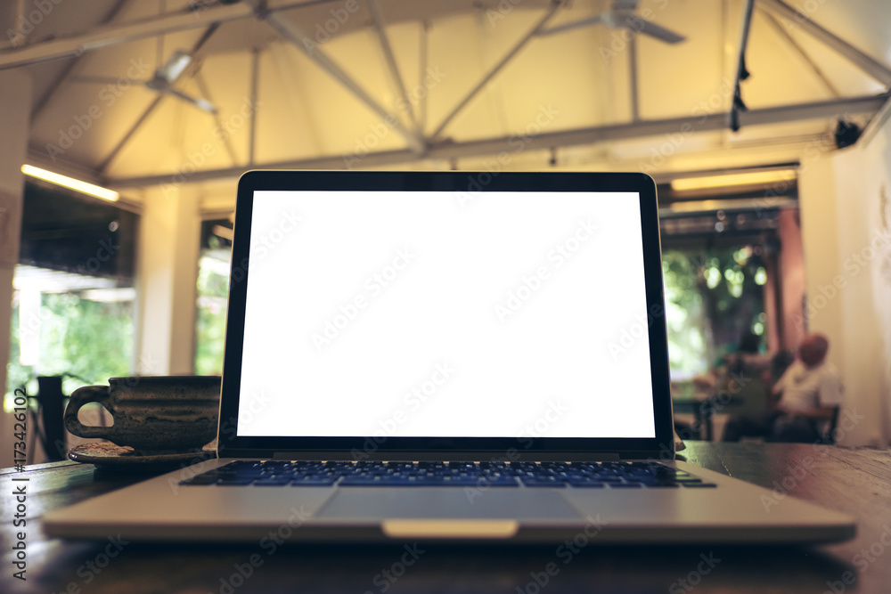 Mockup image of laptop with blank white screen on wooden table in vintage cafe Mockup image of laptop with blank white screen on wooden table in vintage cafe