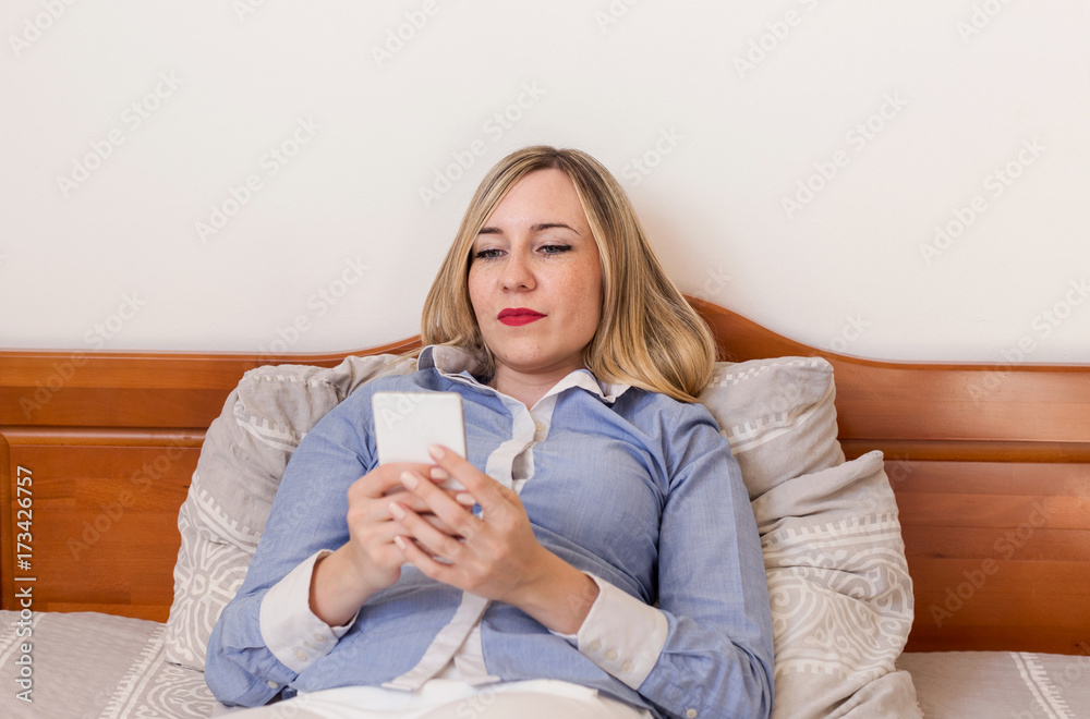 young business woman lying on bed and using phone young business woman lying on bed and using phone