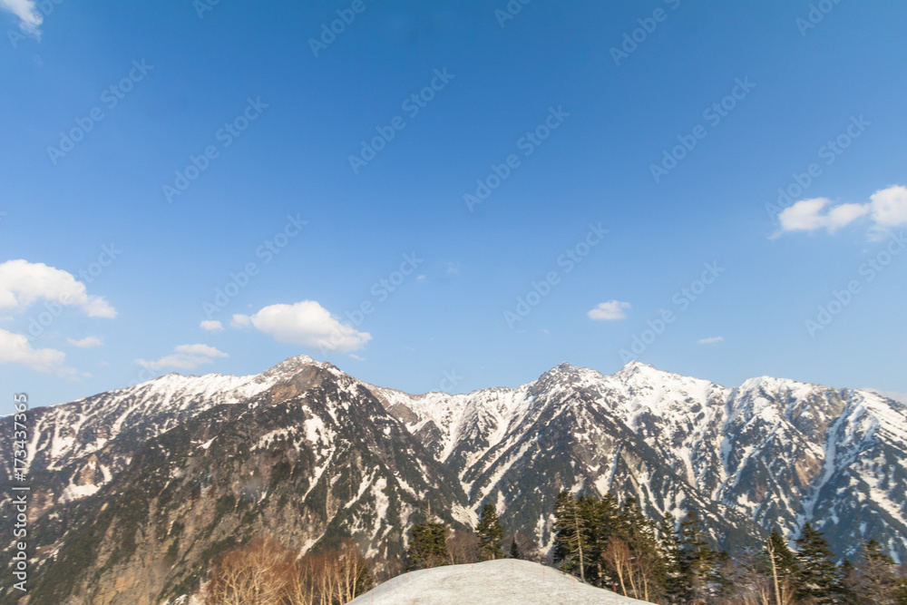  The snow mountains of Tateyama Kurobe alpine  with blue sky  background is  one of the most important and popular natural place in Toyama Prefecture, Japan.