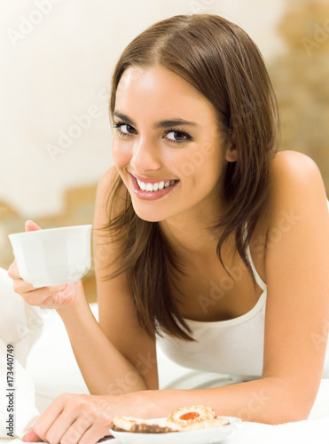 Young happy smiling woman drinking coffee, at home