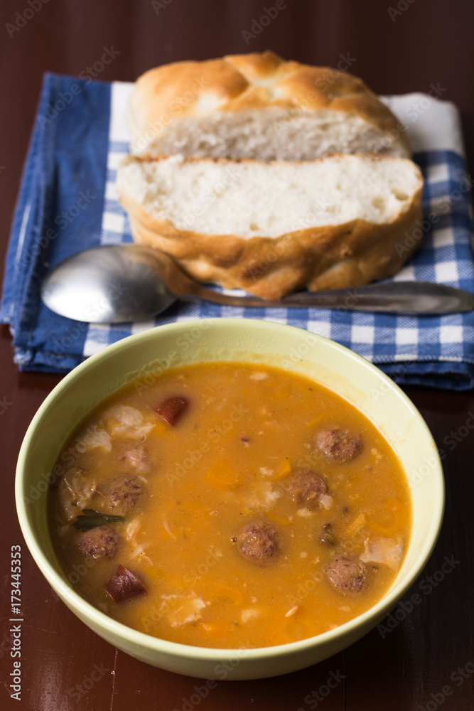 Cooked beans with sausages on the table with bread in the background Cooked beans with sausages on the table with bread in the background