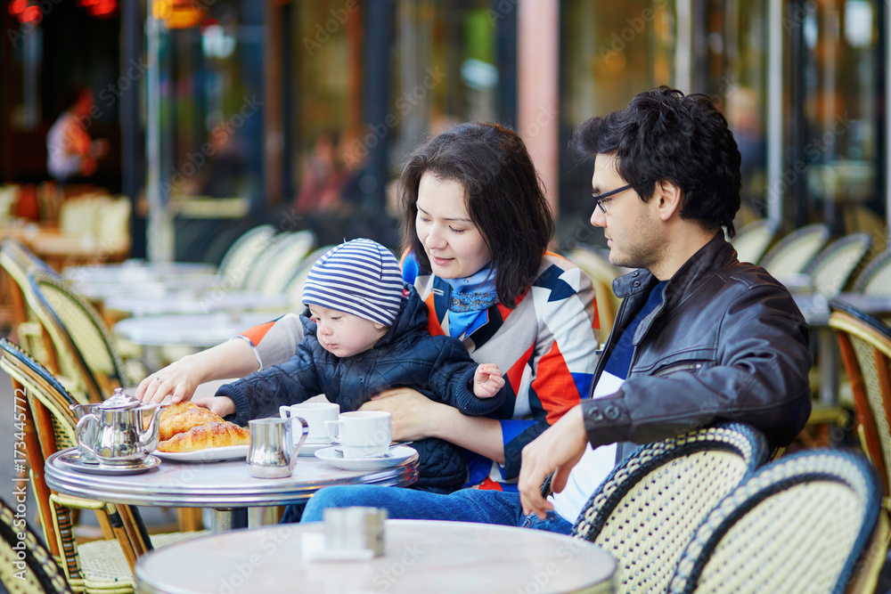 Happy family of three in Parisian outdoor cafe Happy family of three in Parisian outdoor cafe