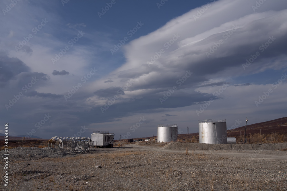 Silver tanks and the sky with lenticular clouds. Polar Urals. Russia.