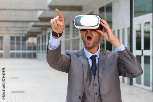 Businessman pointing while using virtual reality glasses