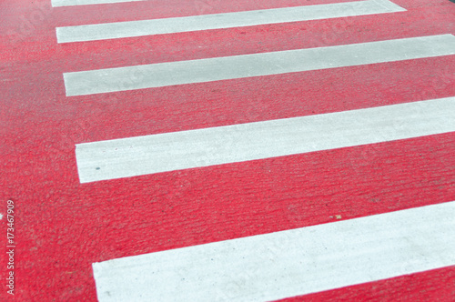 Red painted pedestrian crossing close up.