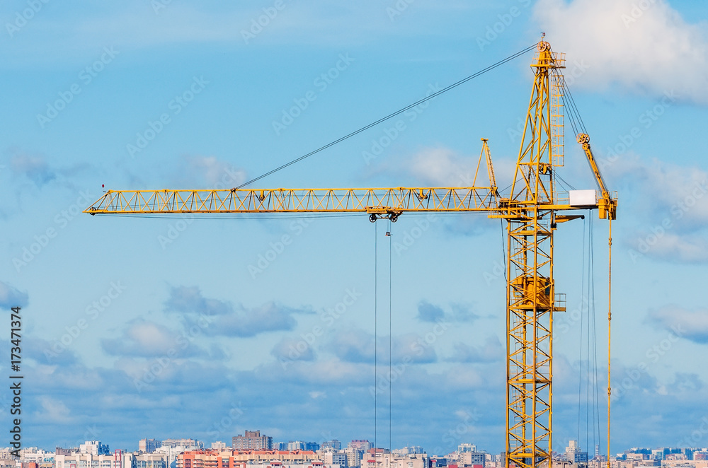 Cranes and housing estate against the background of the city and clouds sky Cranes and housing estate against the background of the city and clouds sky