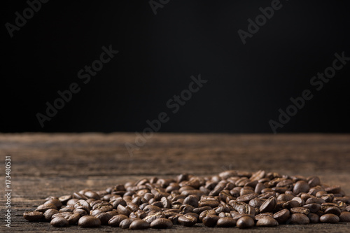 Coffee beans on wooden table with dark background