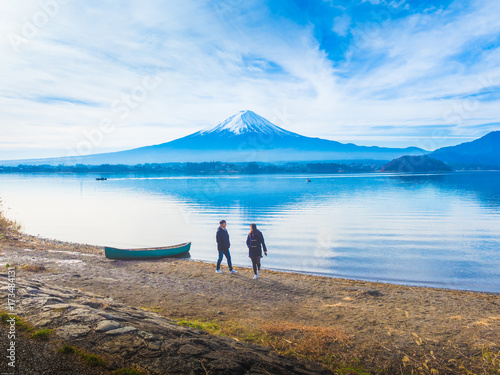 silhouette asia couple traveler 30s to 40s walking and relax at side of lake kawaguchi on morning time with fuji mountain background
