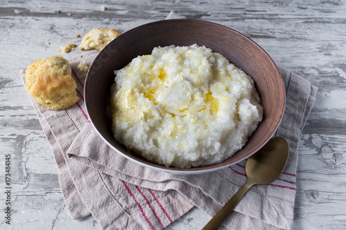 Southern grits with bisquit and butter in rustic setting closeup