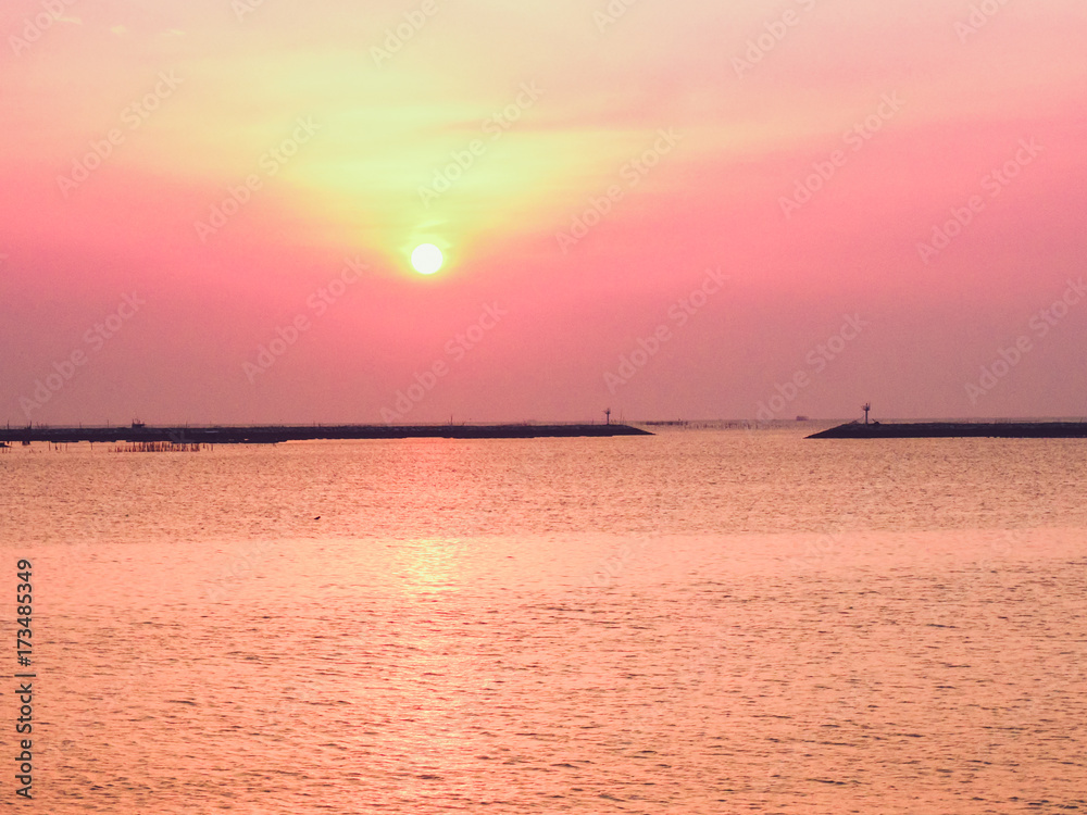 Sunset at a beach in Chonburi City, Thailand. Calm Ocean with colorful sunset sky on background.