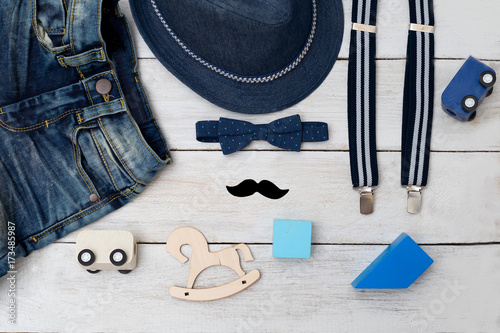 Kids clothing and kids toys on a wooden background. Flat lay