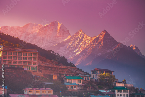 Amazing sunrise view of Namche Bazaar village hotels against mountain peak, Khumbu valley, Nepal. Trekking route to Everest Base Camp, Himalayas. Holidays, sport, recreation. Pink retro vintage toning