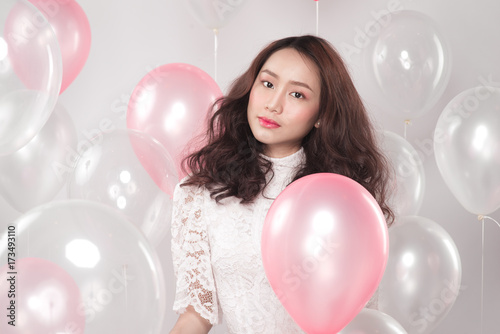 Asian pretty fashionable woman in white dress with pastel balloons © makistock