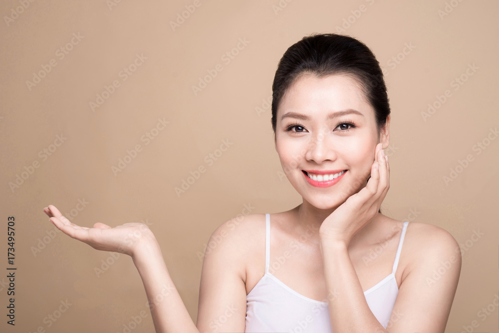 Proposing a product. Beautiful spa woman showing empty copy space on the open hand palm Proposing a product. Beautiful spa woman showing empty copy space on the open hand palm