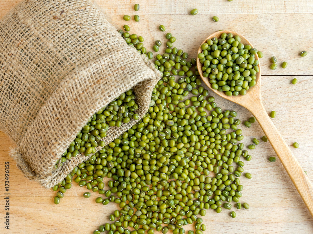 Mung beans(green beans) in a sack, on wood background Mung beans(green beans) in a sack, on wood background