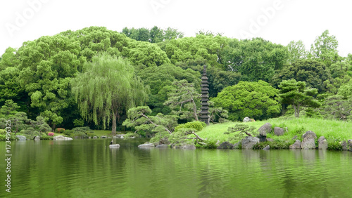 The Japanese outdoor stone lantern and lake in zen green garden