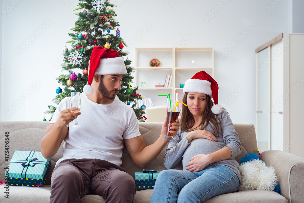 Fototapeta premium Young family expecting child baby celebrating christmas