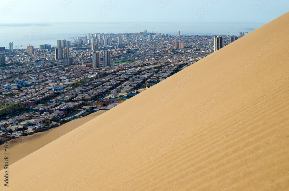 Ocean behind city behind sand dune