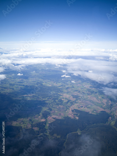 Aerial view to the ground from the airplane. Space and clouds.