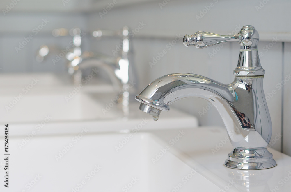 silver faucet or water tap with white washing sink in public toilet. silver faucet or water tap with white washing sink in public toilet.