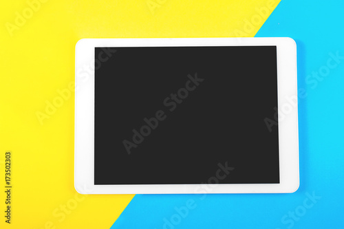 Free Download Digital tablet computer on blue and yellow background. Top view. - GFXLoad
