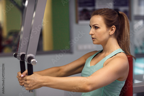 Young fitness woman execute exercise with exercise-machine in the gym.
