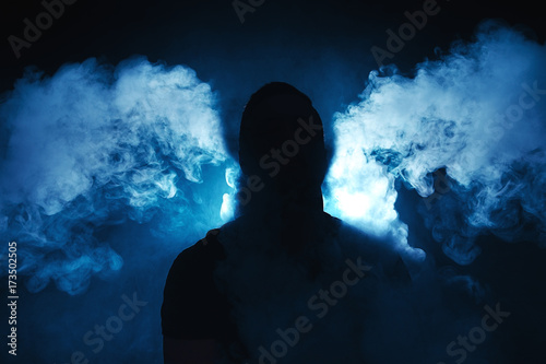vaping man holding a mod. A cloud of vapor.