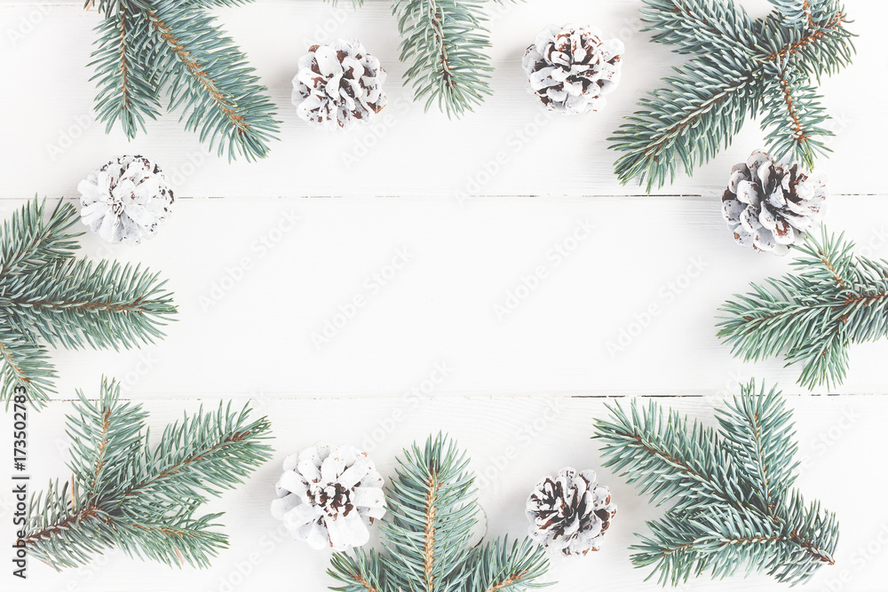 Christmas composition. Frame made of fir branches on white wooden background. Christmas, winter concept. Flat lay, top view, copy space