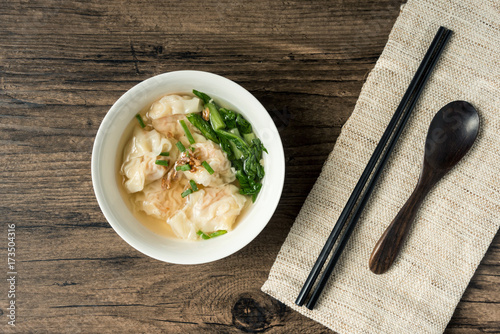 Shrimp wonton with braised pork in soup on wooden table - Asian food style  / Select focus image photo