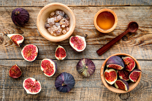 Make jam. Fresh blue figs in bowl, sugar and honey on wooden background top view