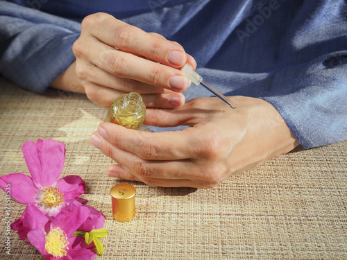 Fotografie Arab woman applying perfume on wrist.