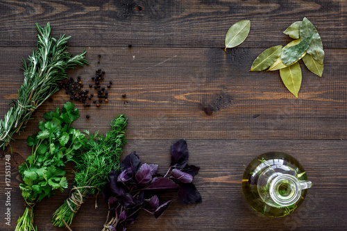 natural oil and fresh greenery for restaurant cooking on wooden kitchen table background top view