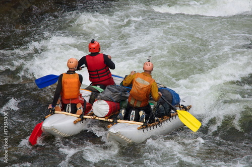 Team of athletes on an inflatable catamaran rafting on white water. Chaya river, North Baikal Highlands, Siberia, Russia. photo