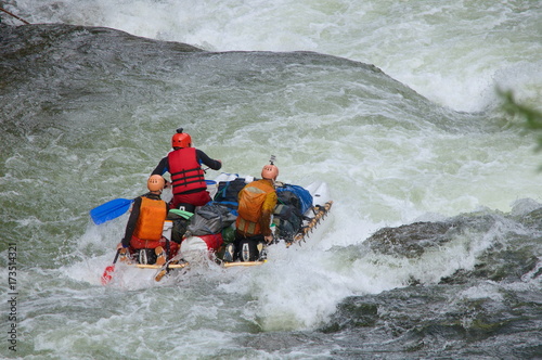 Team of people on an inflatable catamaran rafting on white water. Chaya river, North Baikal Highlands, Siberia, Russia.