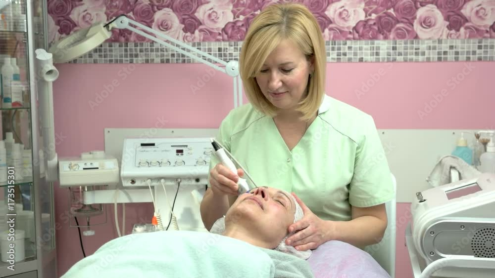 Adult woman, cosmetology procedure. Cosmetologist, radio frequency skin tightening. Beauty clinic advertising.